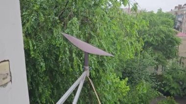 Starlink satellite dish, an internet constellation operated by SpaceX, is installed on the wall of an apartment building.