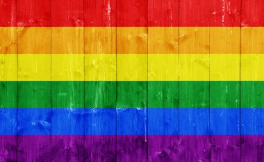 Tahtaların ahşap dokusunun arka planında LGBT topluluğunun bayrağı. Gökkuşağı eşcinsel kültür sembolü. Kavram kolajı. Gururun sembolü..