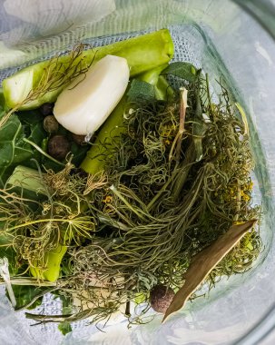 Kış için cam kavanozlarda salatalık turşusu. Tuzlama için baharatlar kavanozlara konur..