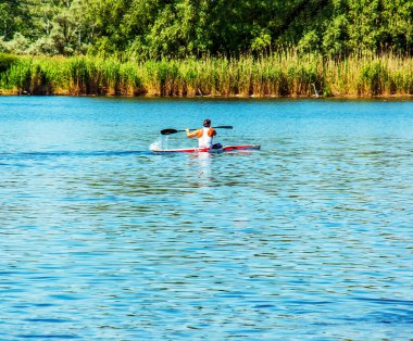 Dnipro, Ukrayna - 06.20.2023: Tek bir sporcunun kano üzerinde kürek çekme tekniği. Kürek sıçratma hareketi.