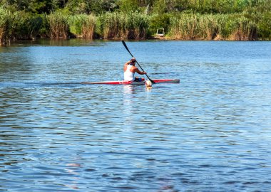 Dnipro, Ukrayna - 06.20.2023: Tek bir sporcunun kano üzerinde kürek çekme tekniği. Kürek sıçratma hareketi.