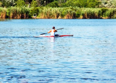Dnipro, Ukrayna - 06.20.2023: Tek bir sporcunun kano üzerinde kürek çekme tekniği. Kürek sıçratma hareketi.