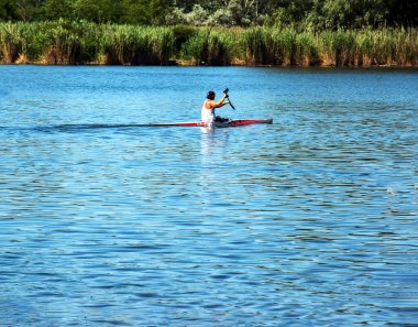 Dnipro, Ukrayna - 06.20.2023: Tek bir sporcunun kano üzerinde kürek çekme tekniği. Kürek sıçratma hareketi.