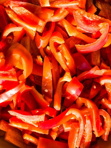 Red fresh bell pepper, sliced. Top view of red cut pepper background. Healthy food concept.