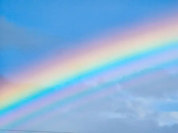 View of a rainbow in a cloudy sky. Double rainbows are a rare phenomenon.