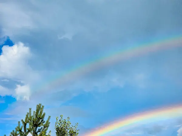 View of a rainbow in a cloudy sky. Double rainbows are a rare phenomenon.