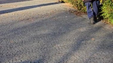 Bir işçi parktaki sonbahar yapraklarını çıkarır. Yakın plan. Şehri kışa hazırlıyorum..