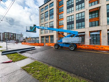 Portland, ABD - 01.27.2024: Bir binanın arka planına karşı mavi çalışma platformu. İnşaat alanında seyyar vinç.