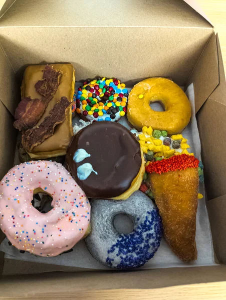 Multi-colored donuts in a box from the Voodoo Donut retail store in Portland.