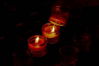 Prayer candles in votives, and insence, inside of a Catholic church