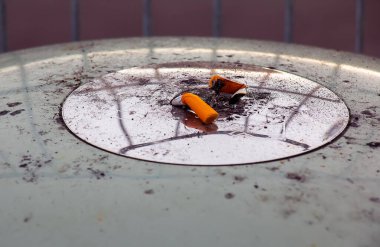 Sigara izmaritleri ve külleri olan kül tablası. Sigara karşıtı konsept.