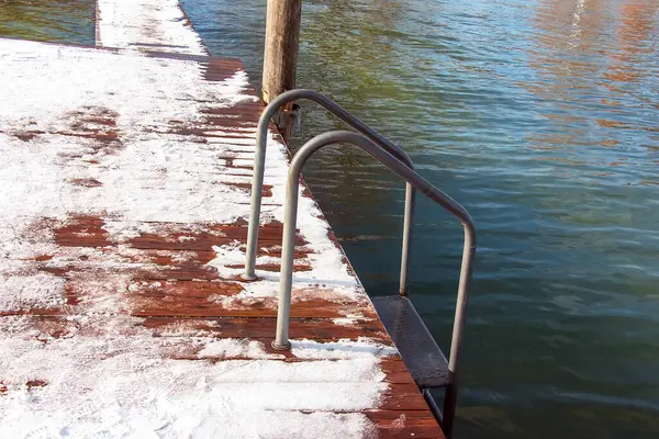 Avusturya 'daki Traunsee Gölü' ne merdivenleri olan karda küçük ahşap iskele..