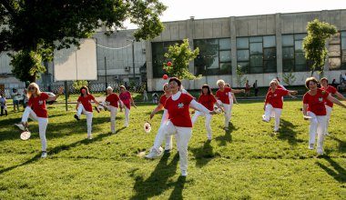 Dnepr, Ukrayna - 06.21.2021: Parkta tenis topu ve raketle sağlık ve spor yapan bir grup yaşlı insan.