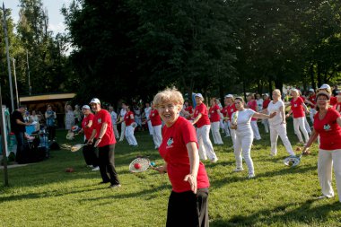 Dnepr, Ukrayna - 06.21.2021: Parkta tenis topu ve raketle sağlık ve spor yapan bir grup yaşlı insan.