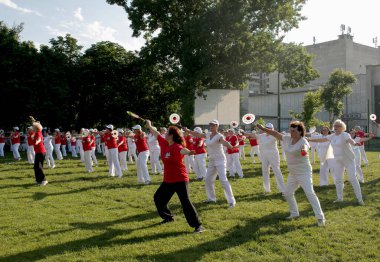 Dnepr, Ukrayna - 06.21.2021: Parkta tenis topu ve raketle sağlık ve spor yapan bir grup yaşlı insan.