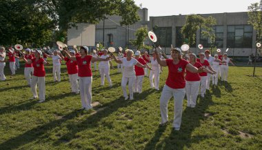 Dnepr, Ukrayna - 06.21.2021: Parkta tenis topu ve raketle sağlık ve spor yapan bir grup yaşlı insan.