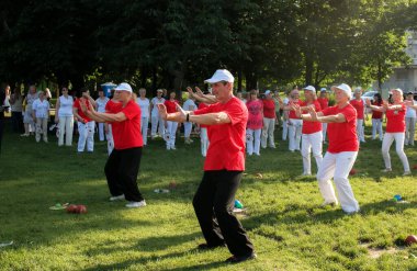 Dnepr, Ukrayna - 06.21.2021: Parkta sağlık ve spor yapan bir grup yaşlı insan.
