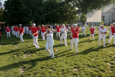 Dnepr, Ukrayna - 06.21.2021: Parkta bir topla sağlık ve spor yapan bir grup yaşlı insan.