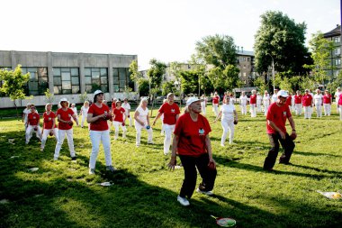 Dnepr, Ukrayna - 06.21.2021: Parkta bir topla sağlık ve spor yapan bir grup yaşlı insan.