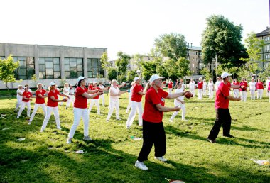 Dnepr, Ukrayna - 06.21.2021: Parkta bir topla sağlık ve spor yapan bir grup yaşlı insan.