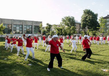 Dnepr, Ukrayna - 06.21.2021: Parkta bir topla sağlık ve spor yapan bir grup yaşlı insan.