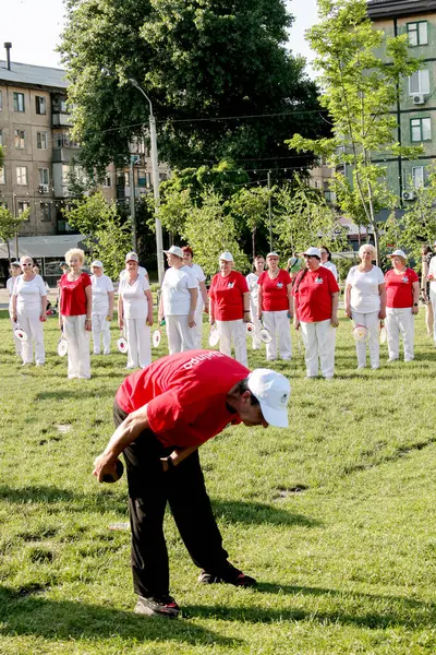 Dnepr, Ukrayna - 06.21.2021: Parkta bir topla sağlık ve spor yapan bir grup yaşlı insan.