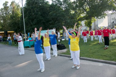 Dnepr, Ukrayna - 06.21.2021: Parkta bir topla sağlık ve spor yapan bir grup yaşlı insan.