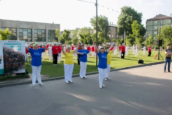 Dnepr, Ukrayna - 06.21.2021: Parkta bir topla sağlık ve spor yapan bir grup yaşlı insan.