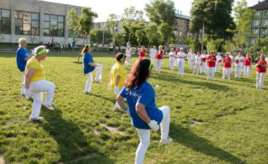 Dnepr, Ukrayna - 06.21.2021: Parkta sağlık ve spor yapan bir grup yaşlı insan.