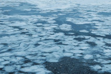 Buz gibi bir nehir yüzeyinin tasviri. Buz ve su parçalarının dokusu. Kış arkaplanı.