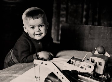 Çocuk inşaat setiyle oynayan küçük bir çocuğun portresi. 1971. Retro, vintage.