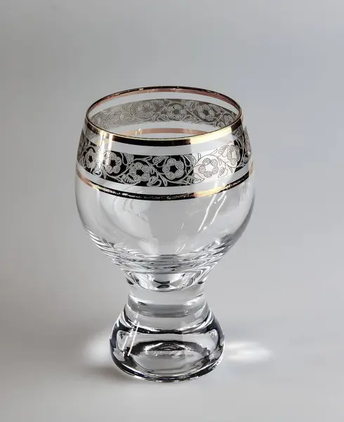 Empty glass Bohemia inlaid with gold on a white background.