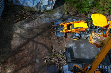 Bir buldozer ağaçları budadıktan sonra dalları toplar. Yukarıdan görüntüle.