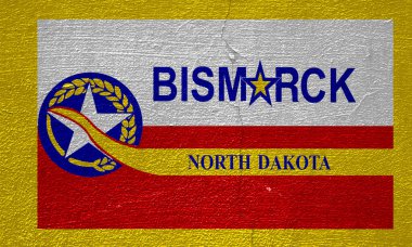 Flag of the city of Bismarck, North Dakota, USA, on a background of a cracked wall. Conceptual collage. clipart