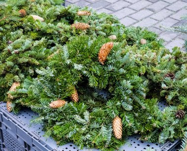 Noel ağacı pazarında taze ağaç dalları ve çam kozalaklarından yapılmış bir sürü Noel çelengi. Noel için hazırlanılıyor