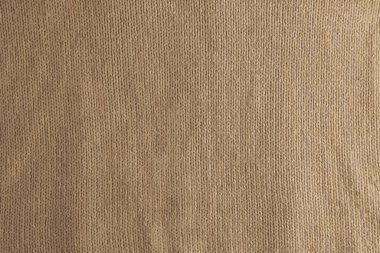 Bej örülmüş halıyı yakından gösteren gerçekçi bir tasvir. Bej arka planda tekstil dokusu. Ayrıntılı sıcak iplik arka planı. Doğal yün kumaş, süveter parçası..