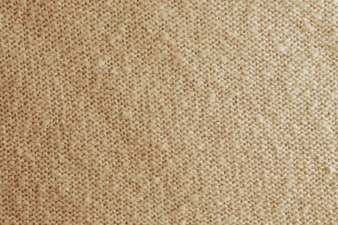 Bej örülmüş halıyı yakından gösteren gerçekçi bir tasvir. Bej arka planda tekstil dokusu. Ayrıntılı sıcak iplik arka planı. Doğal yün kumaş, süveter parçası..