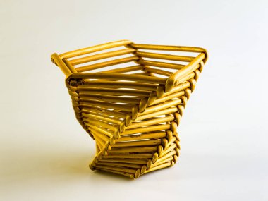 Beyaz arka planda alışılmadık bir sepet örülmüş saman..