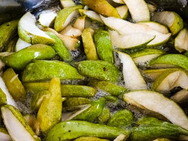 Hazırlık aşamasında armut reçeli. Şerbetli haşlanmış armut parçaları..