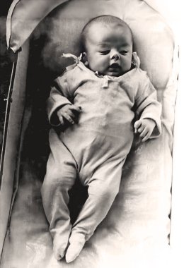 Retro fotoğraf. Üç aylık küçük bir bebek bebek bebek arabasında yatıyor. 1967 yılının klasik portresi..