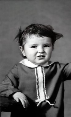 Fiyonklu üç yaşında şirin bir kızın klasik portresi. 1970 'ten kalma eski bir fotoğraf.