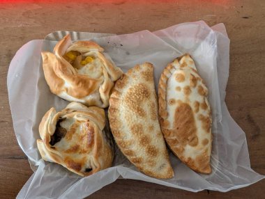 Empanada geleneksel bir Arjantin yemeğidir. Teslimat kutusunda farklı dolgular olan bir sürü börek..