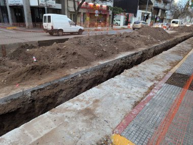 Cordoba, Arjantin - 08 Mayıs 2025: İnşaat işleri. Şehir merkezine yeraltı tesisleri kuruyor. Siper ve toprak döşeme araçları.