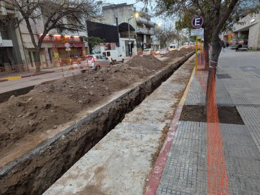 Cordoba, Argentina - May 08, 2025: Construction work. Laying underground utilities in city center. Trench and soil dumps for laying utilities.