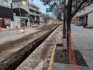 Cordoba, Argentina - May 08, 2025: Construction work. Laying underground utilities in the city center. Trench and soil dumps for the laying utilities.