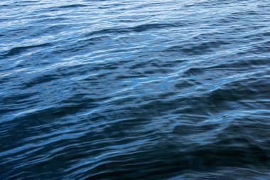 Alplerdeki Traunsee Gölü 'nün su arka planı. Berrak bir dağ gölünün rengarenk yansımaları. Yansımalı su dokusu.