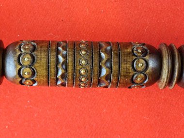 Kırmızı arka planda Ukrayna hatıra topuzu. El yapımı, ahşap, pirinç. Sapın ayrıntıları.