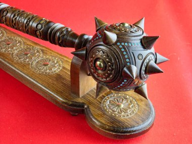 Kırmızı arka planda duran Ukrayna hatıra topuzu. Pirinçle el yapımı ahşap..