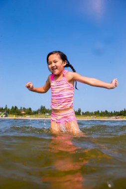 Mutlu kız oynuyor ve sahilde eğleniyor.