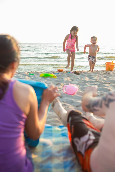mutlu karışık ırk aile dört oynama ve plajda eğlenmek